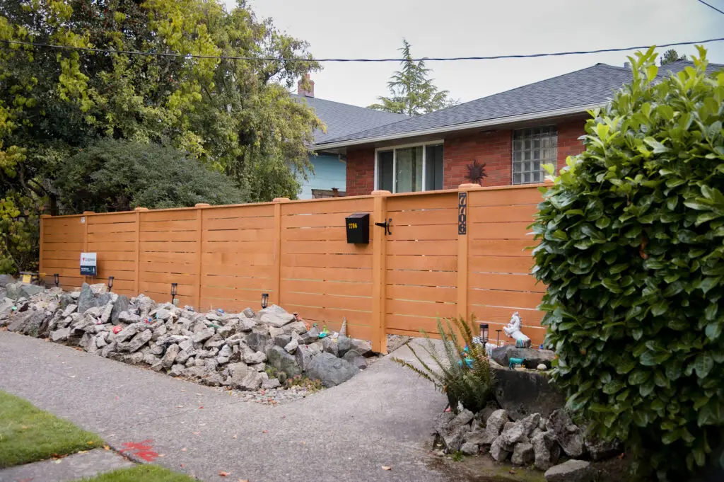 Long cedar fence with horizontal slats at a Seattle home, designed for privacy and durability in rainy climates.
