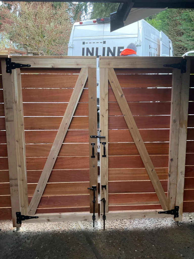 Close-up of a high, double horizontal cedar gate with sturdy diagonal bracing and matte black hardware, perfectly designed under Horizontal fence height rules.