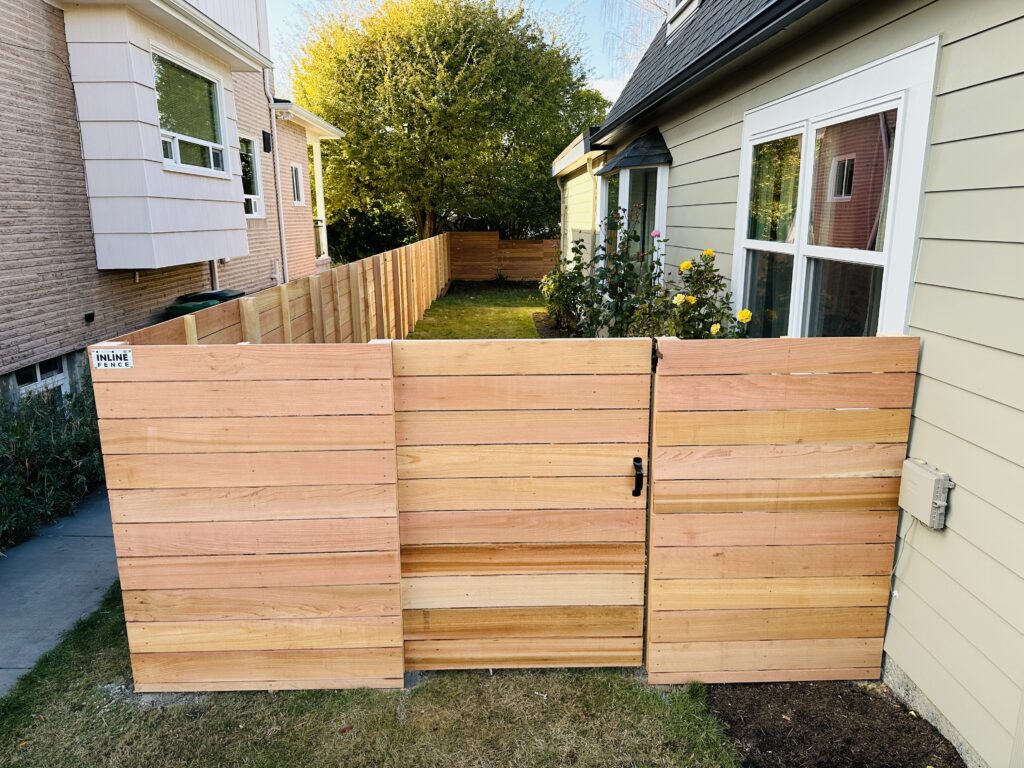 Modern cedar fence with horizontal slats installed in a Seattle backyard, offering both privacy and style.