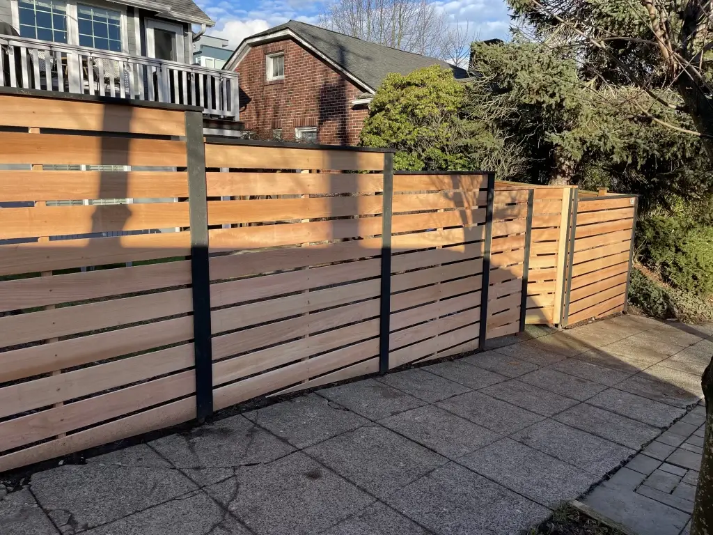 A modern horizontal wood fence with metal posts, showcasing the sleek design of Horizontal Wood Fences Seattle.