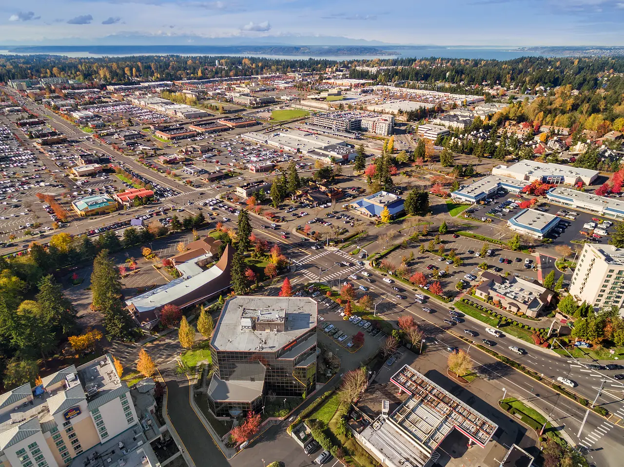Aerial view of Federal Way, WA, with commercial buildings, parking, and Puget Sound.