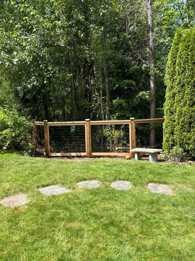 Cedar frame hog wire fence with clear cedar boards and post caps in a Renton backyard