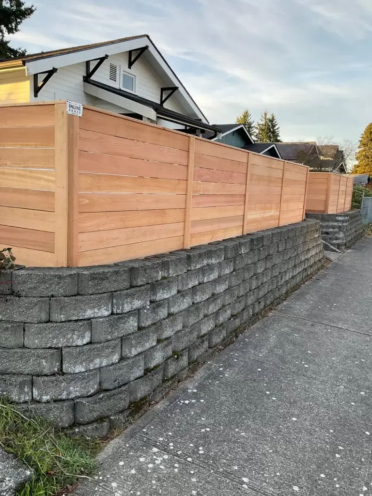 A modern horizontal cedar fence with a concrete base installed in a Seattle residential area, providing privacy and durability.