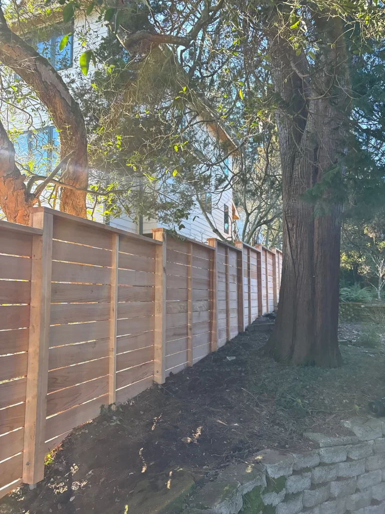 Horizontal cedar fence with clear cedar boards and a natural landscape in Seattle, with trees nearby