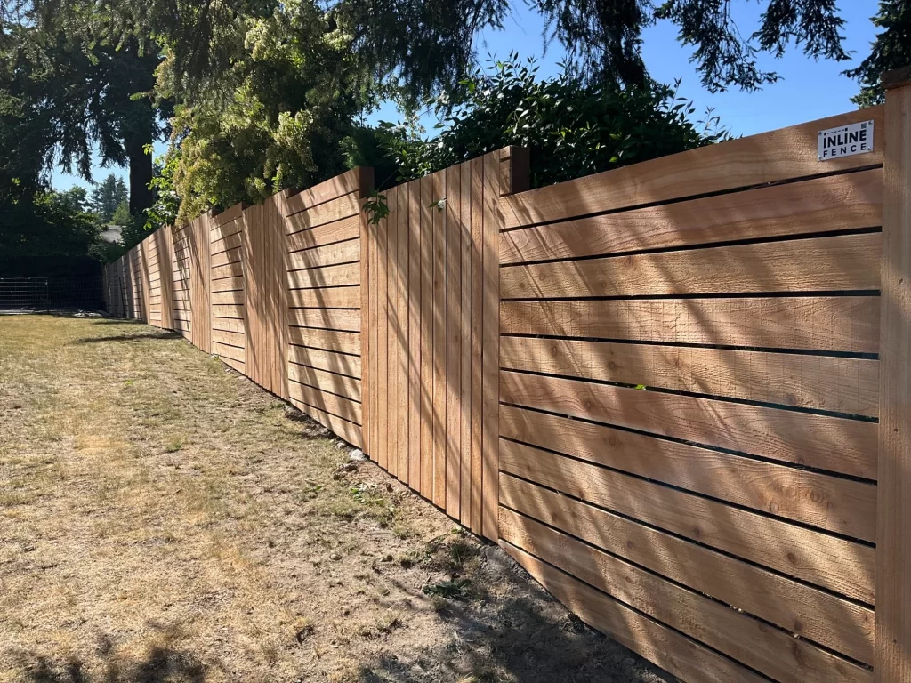 A modern horizontal cedar fence installed in a Seattle backyard, demonstrating sleek design and showcasing cedar fence staining vs sealing in Seattle.