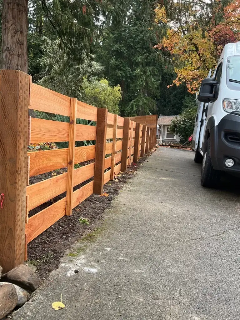 A clean and modern Horizontal Cedar Fence Seattle, enhancing the property's curb appeal along the driveway.