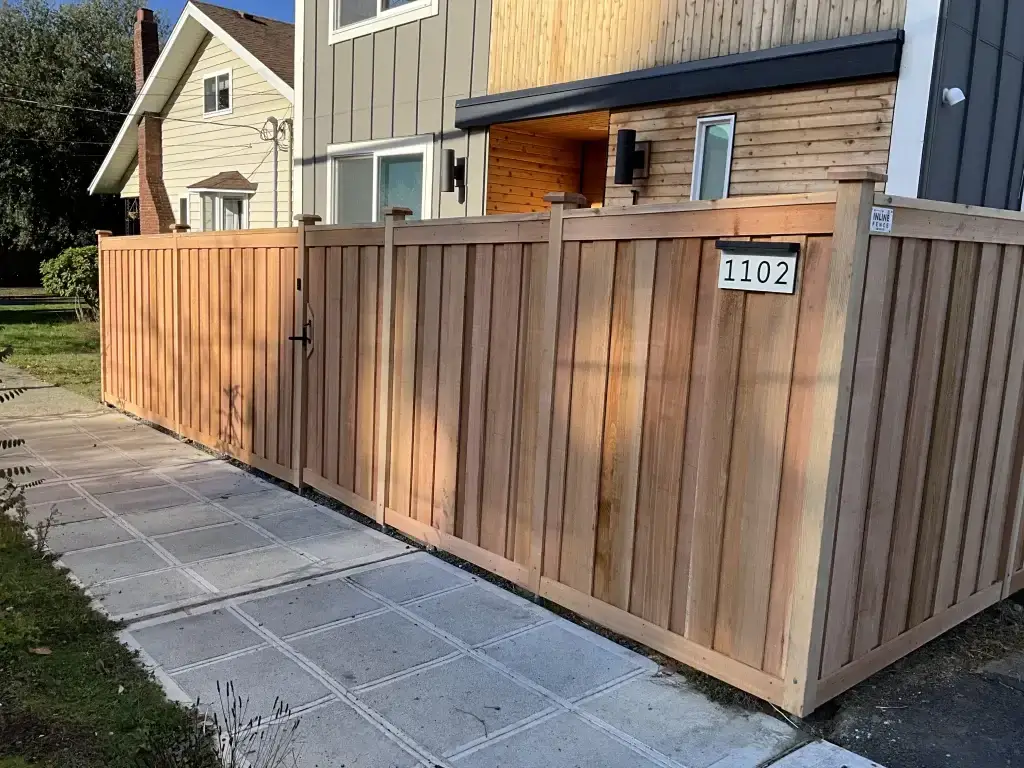 A neatly installed Horizontal Cedar Fence in Seattle with a gate and house number visible, offering privacy and style.