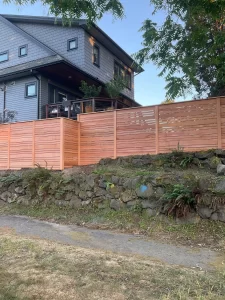 A modern horizontal fence at the base of a house, meeting horizontal fence height rules for privacy and style.