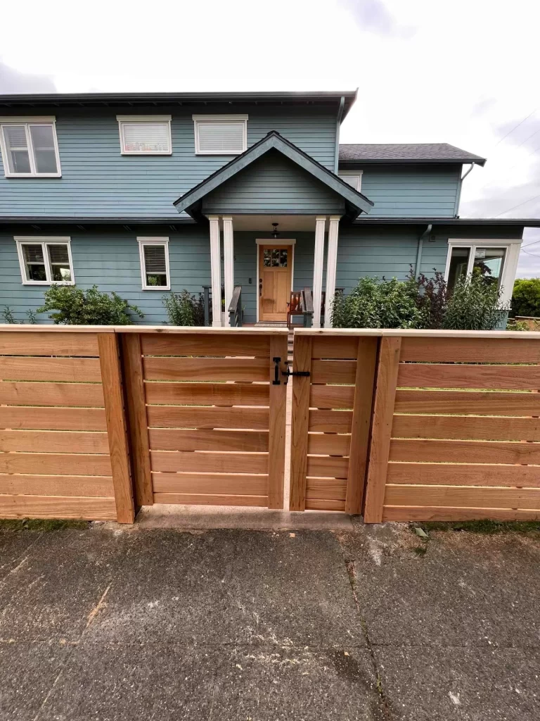 A professional installation of horizontal wooden fences Seattle style, showcasing clean lines and modern backyard privacy.
