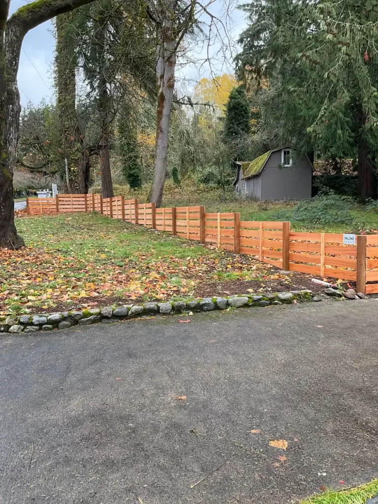 A well-maintained cedar fence with Inline Fence branding lining a Seattle property.