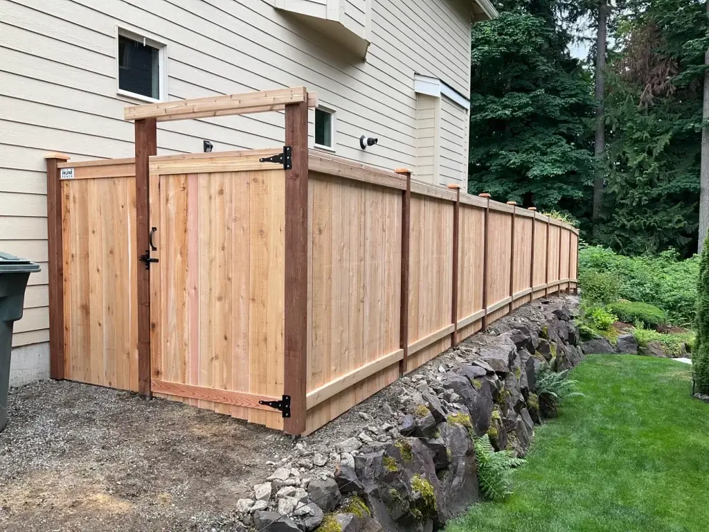 A pipe fence with wood panels and a matching gate, providing both privacy and security.
