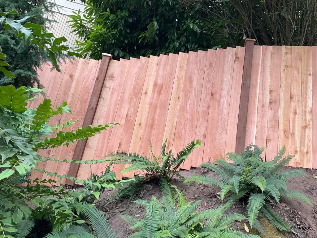 A cedar fence panel installed on a slope, enhancing the natural beauty and privacy of a residential property.