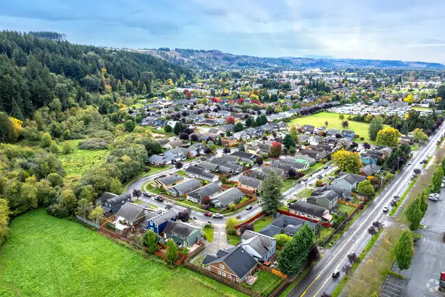 Aerial view of Sumner, WA, with suburban homes, green fields, and autumn trees.