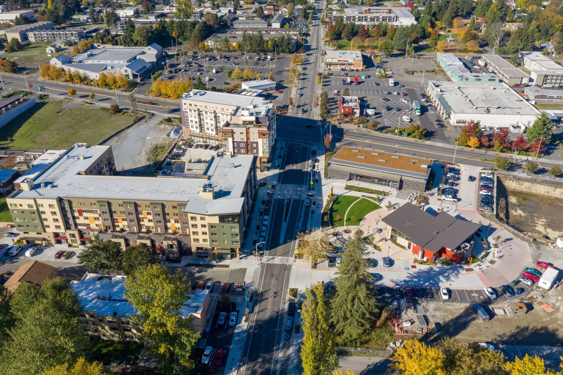 Aerial view of Tukwila, WA, with apartments, parking lots, and autumn trees.