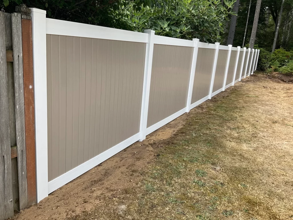 A two-tone vinyl fence with a seamless look, ideal for closing vinyl fence gaps and enhancing backyard privacy.