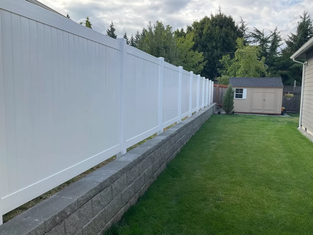 A white vinyl fence on a concrete base, a great solution to close vinyl fence gaps and ensure privacy.