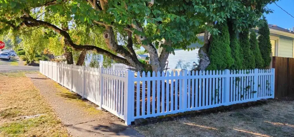 Picket-style vinyl fence installed around a garden in Seattle, perfect for vinyl fence repair Seattle and landscaping.