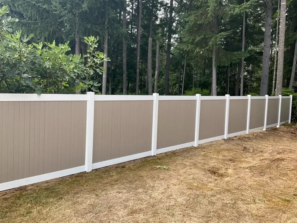 A two-tone vinyl fence installed in a Seattle backyard, offering privacy and strength for vinyl fence repair Seattle.