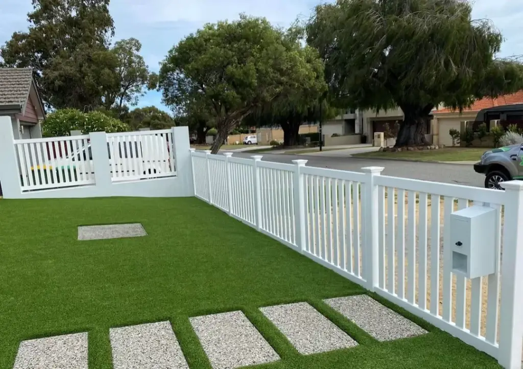 A white vinyl PVC fence with a clean, modern look, enhancing the front yard with its neat design