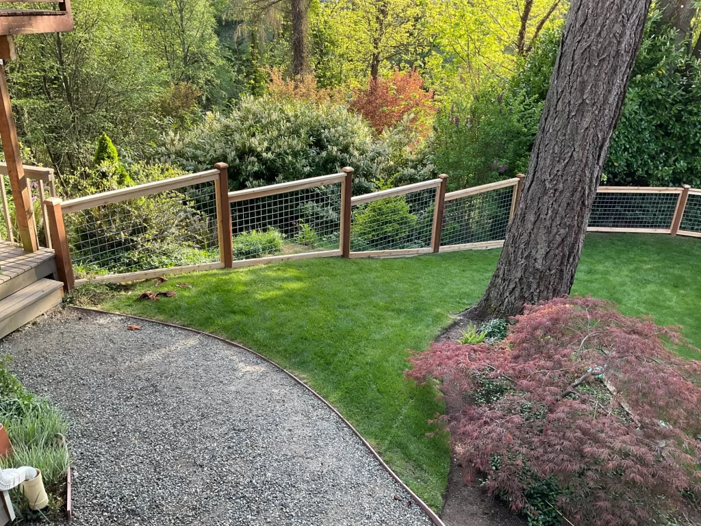 A wood and wire fence in a Seattle backyard, showcasing a blend of style and functionality with the Best fence materials for Seattle.